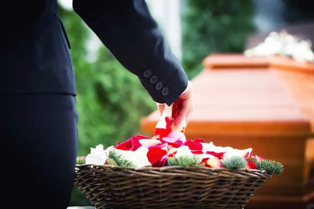 photo of funeral casket and a basket of flowers